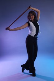 Photo of Teenage girl in tap shoes with cane dancing on color background