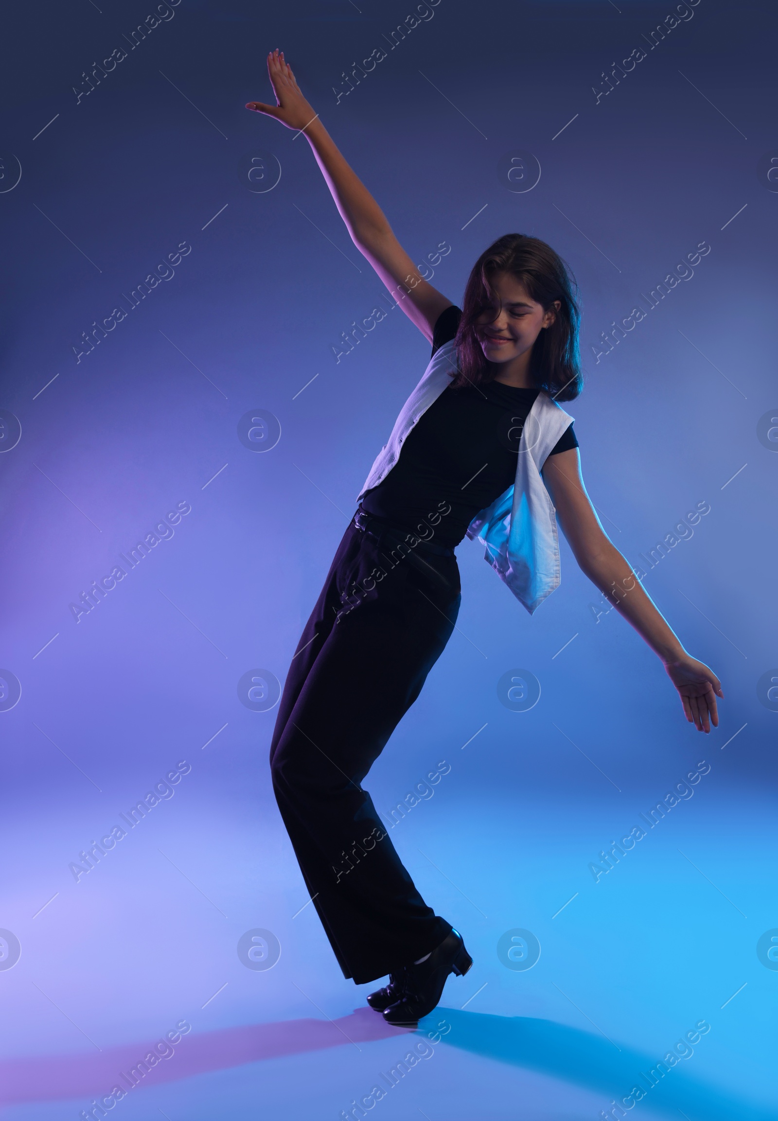 Teenage girl in tap shoes dancing on color background Photo of Teenage girl in tap shoes dancing on color background