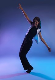 Photo of Teenage girl in tap shoes dancing on color background