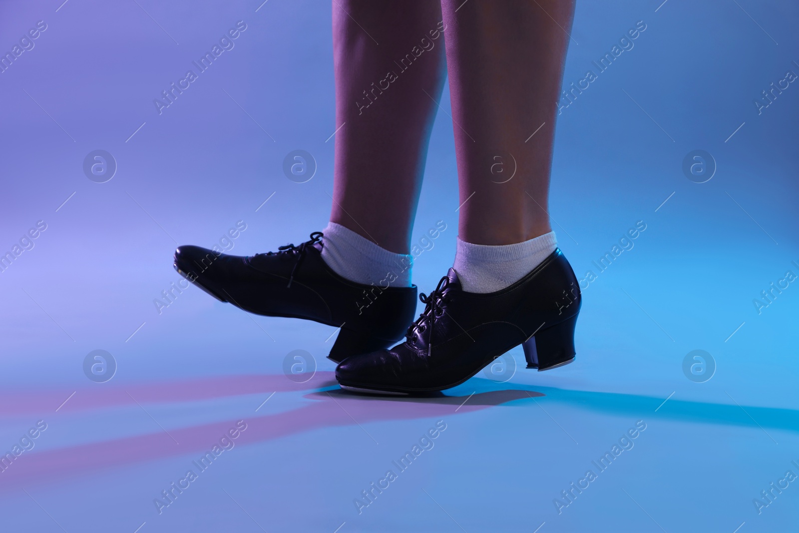 Teenage girl in tap shoes dancing on color background, closeup Photo of Teenage girl in tap shoes dancing on color background, closeup