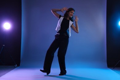 Photo of Teenage girl in tap shoes dancing on color background