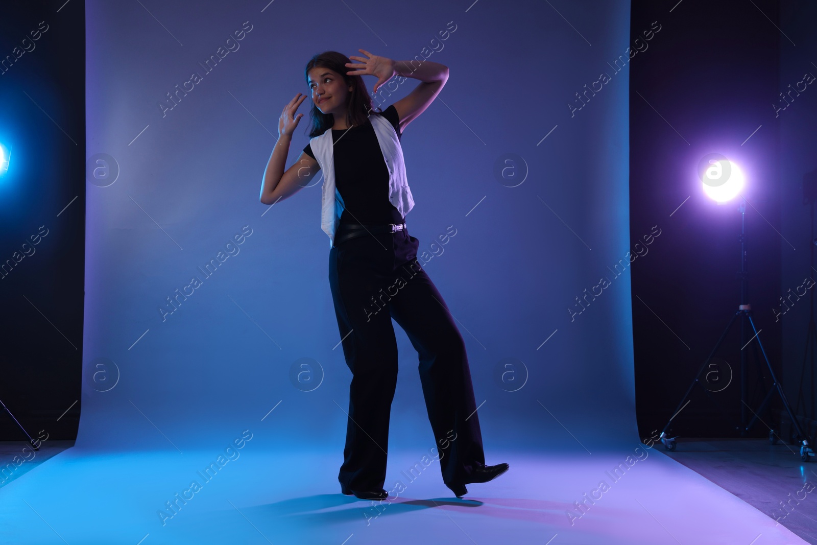 Teenage girl in tap shoes dancing on color background Photo of Teenage girl in tap shoes dancing on color background