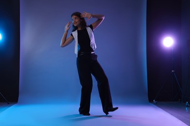 Photo of Teenage girl in tap shoes dancing on color background
