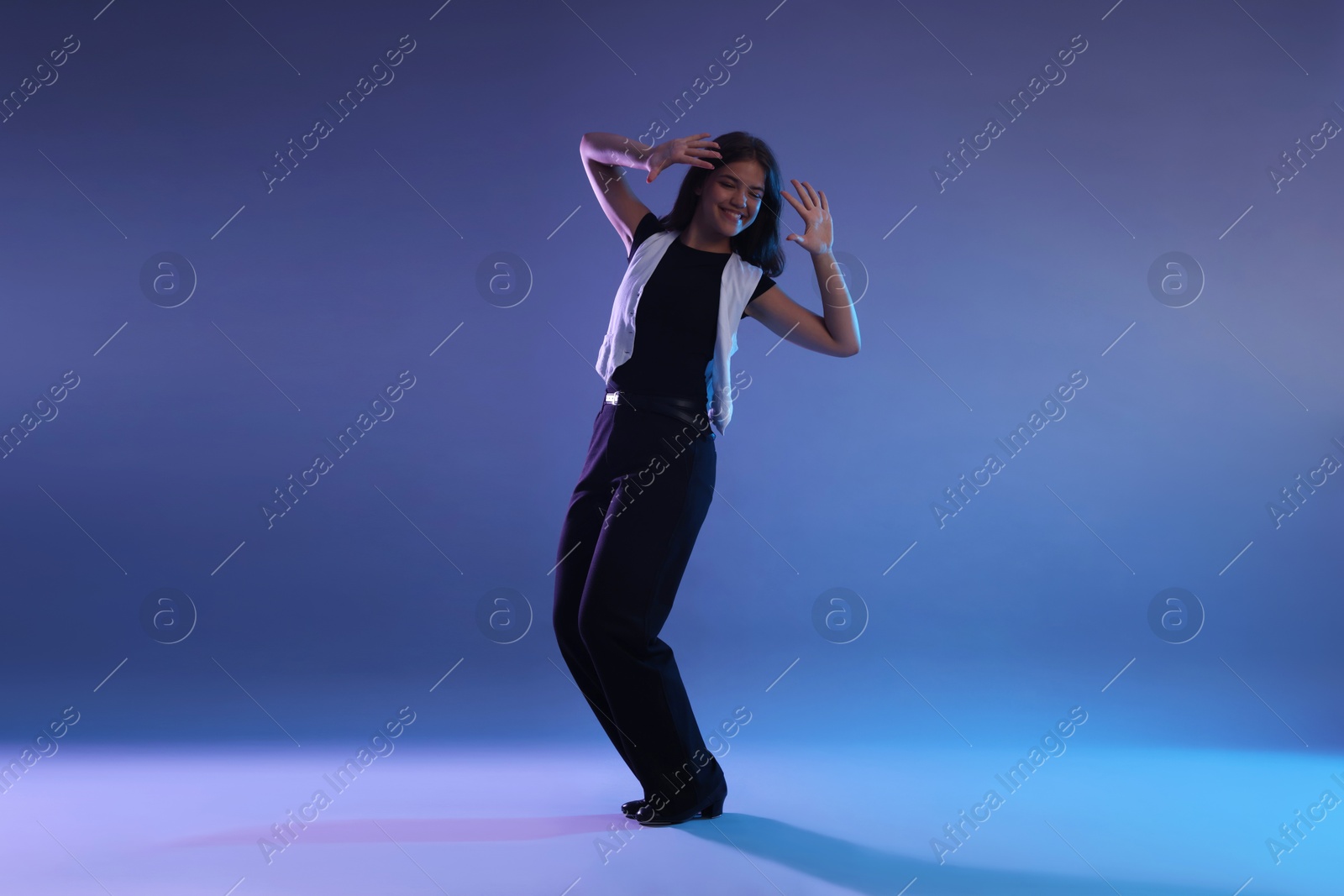 Teenage girl in tap shoes dancing on color background Photo of Teenage girl in tap shoes dancing on color background