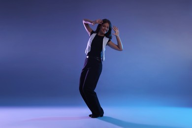 Photo of Teenage girl in tap shoes dancing on color background