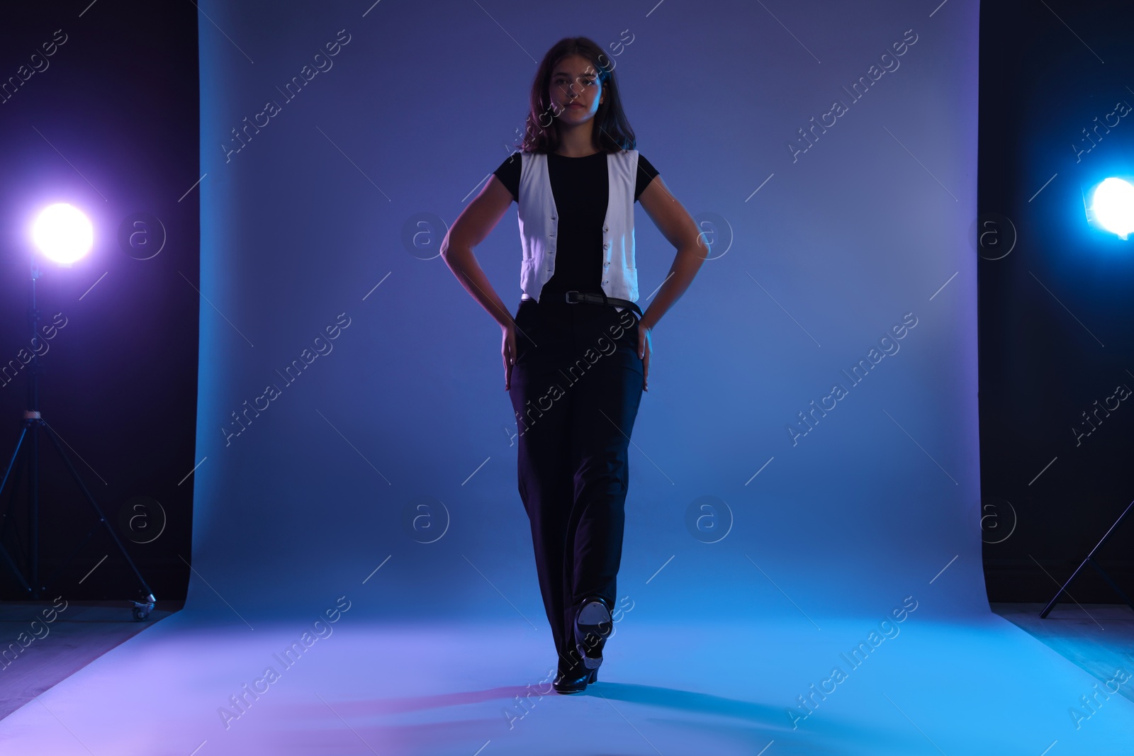 Teenage girl in tap shoes dancing on color background Photo of Teenage girl in tap shoes dancing on color background