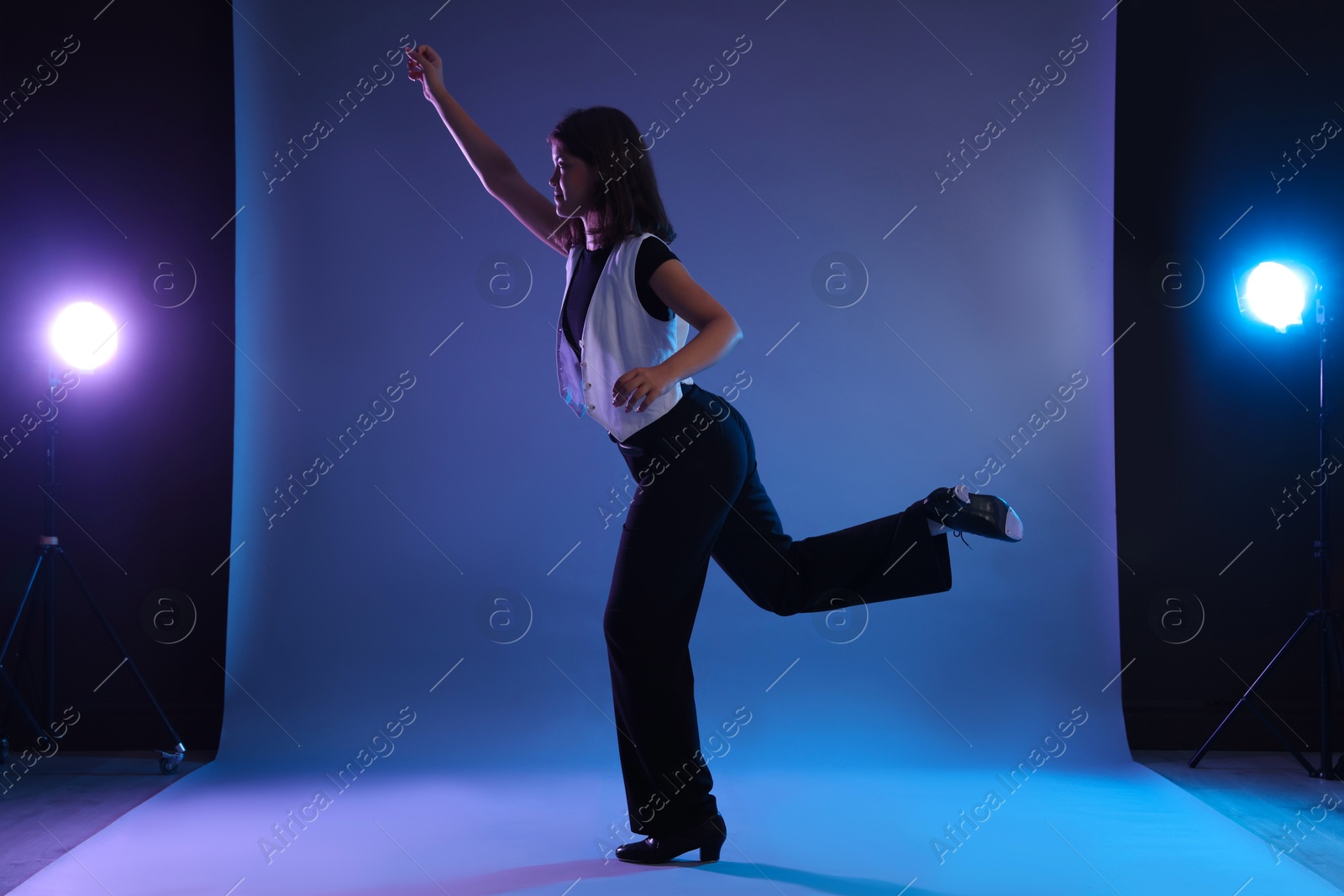 Teenage girl in tap shoes dancing on color background Photo of Teenage girl in tap shoes dancing on color background