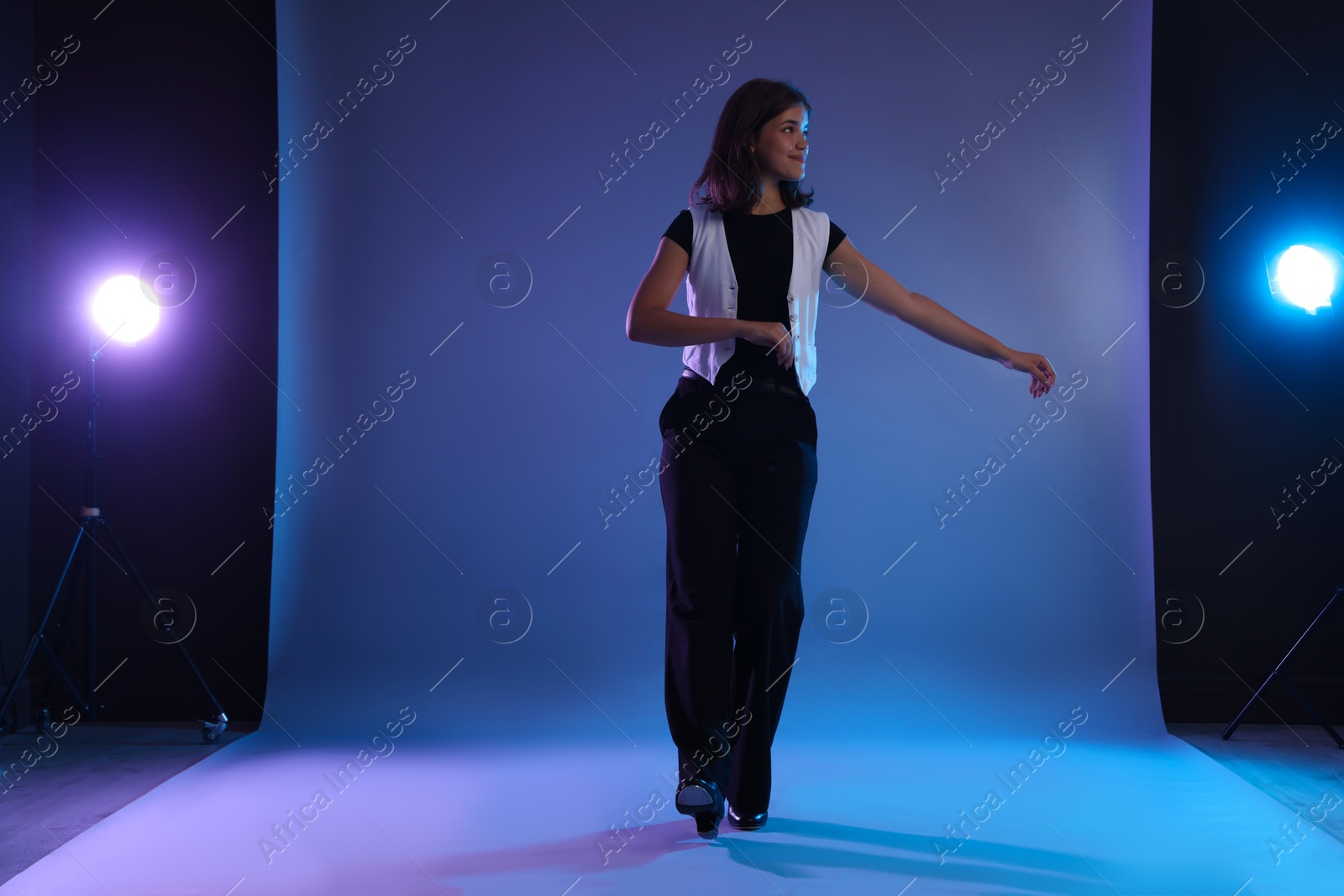 Teenage girl in tap shoes dancing on color background Photo of Teenage girl in tap shoes dancing on color background