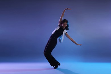 Photo of Teenage girl in tap shoes dancing on color background