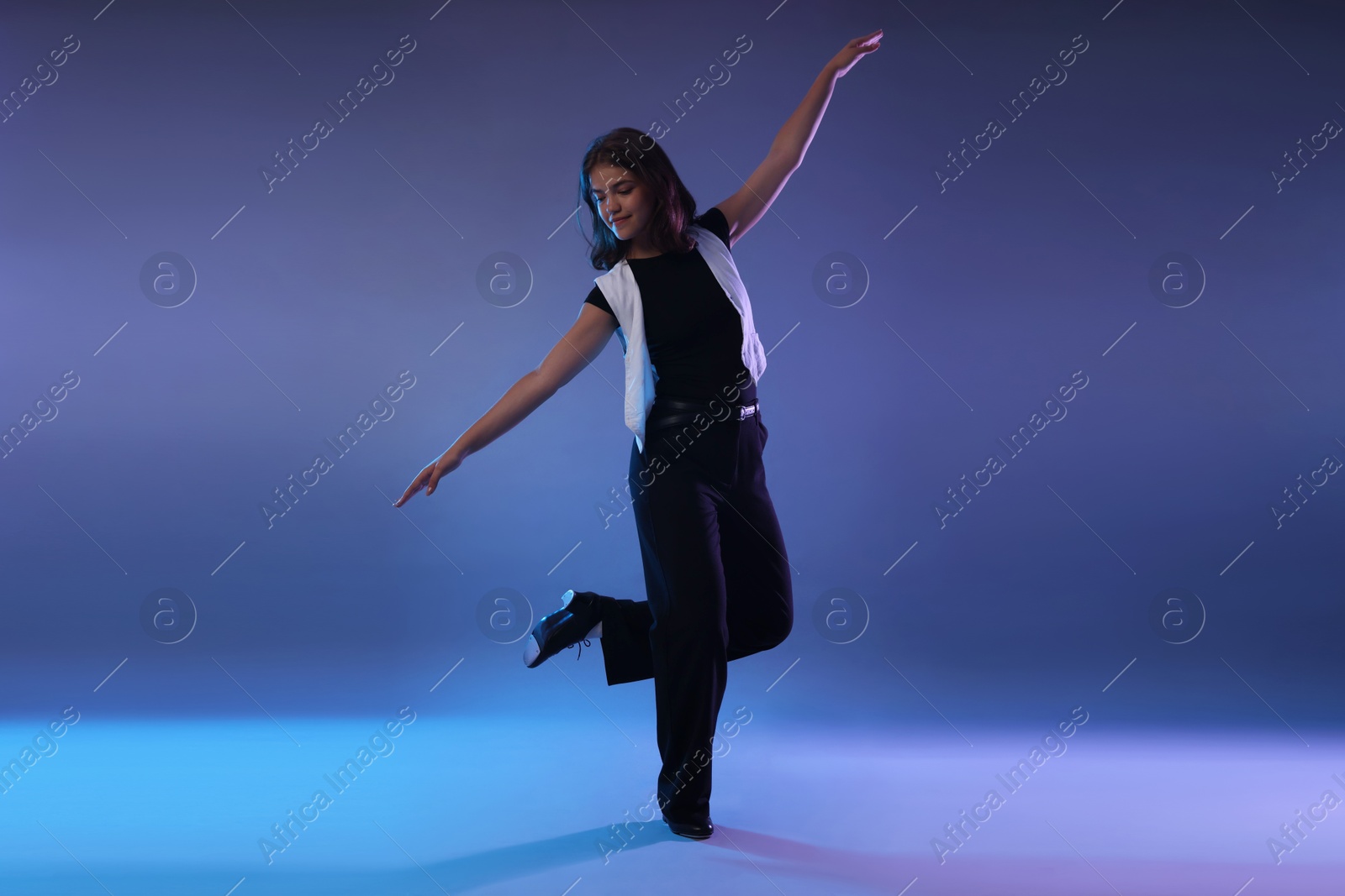 Teenage girl in tap shoes dancing on color background Photo of Teenage girl in tap shoes dancing on color background