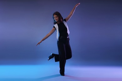 Photo of Teenage girl in tap shoes dancing on color background