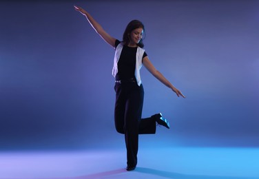 Photo of Teenage girl in tap shoes dancing on color background