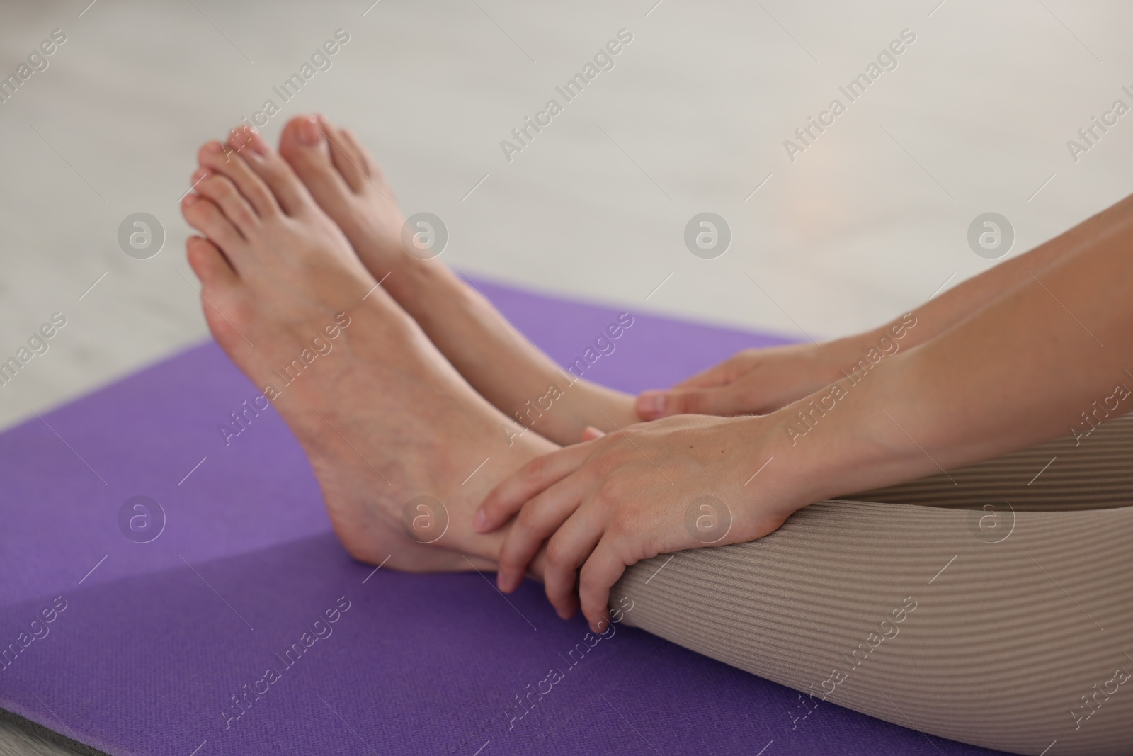 Woman stretching on mat at home, closeup Photo of Woman stretching on mat at home, closeup