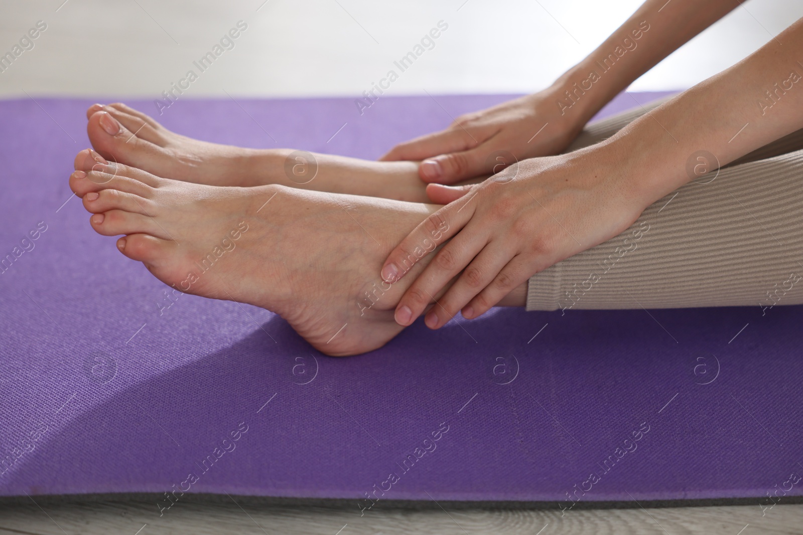 Woman stretching on mat at home, closeup Photo of Woman stretching on mat at home, closeup
