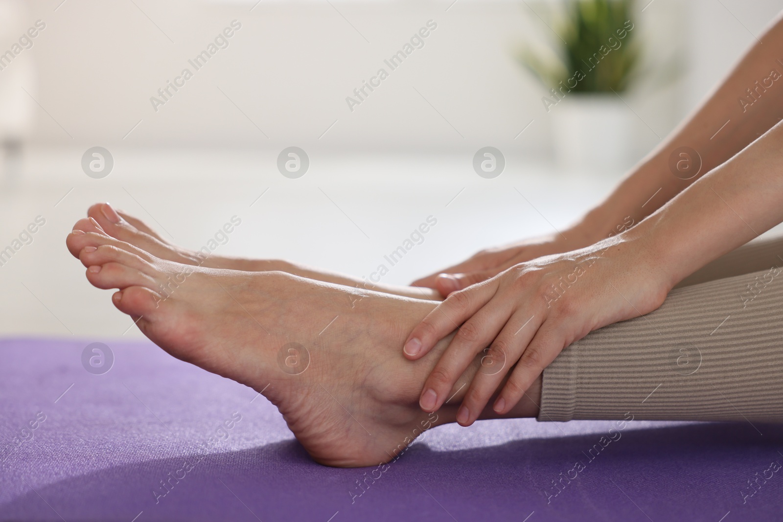 Woman stretching on mat at home, closeup Photo of Woman stretching on mat at home, closeup