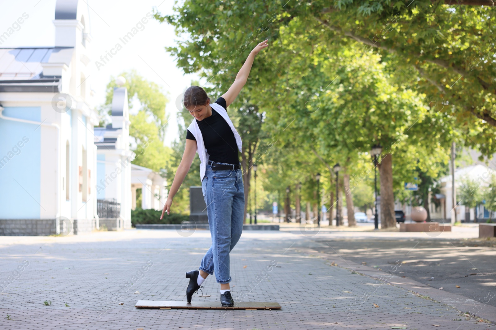 Teenage girl in tap shoes dancing outdoors Photo of Teenage girl in tap shoes dancing outdoors