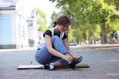 Photo of Teenage girl putting on tap shoes outdoors