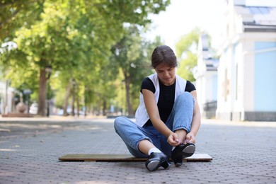 Photo of Teenage girl putting on tap shoes outdoors