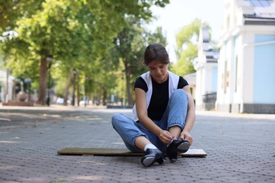 Photo of Teenage girl putting on tap shoes outdoors