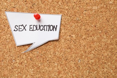 Photo of Note with phrase Sex Education pinned on cork board, closeup