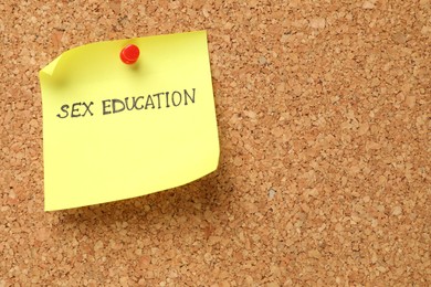 Photo of Note with phrase Sex Education pinned on cork board, closeup