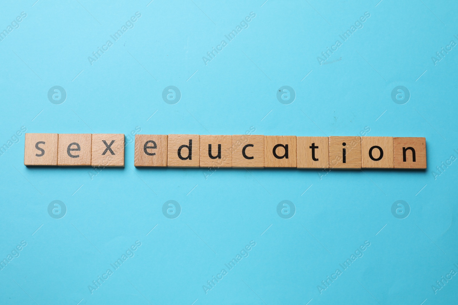 Photo of Phrase Sex Education made with wooden letters on blue background, top view