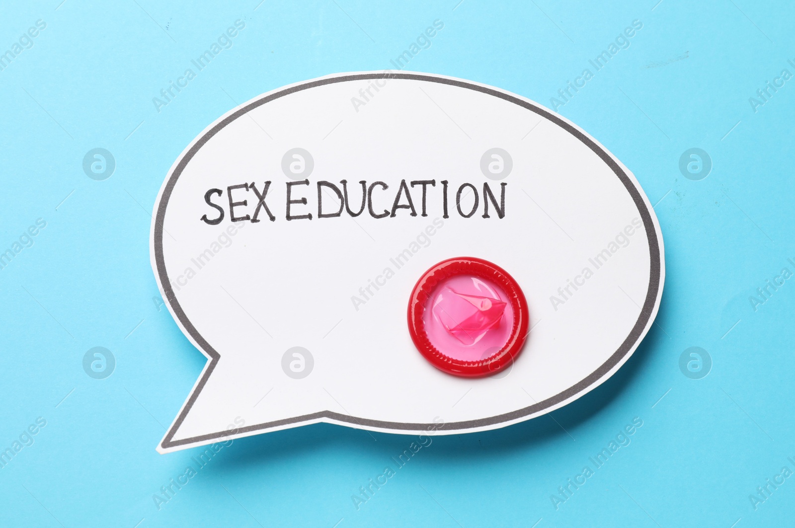 Photo of Speech bubble with phrase Sex Education and condom on light blue background, top view