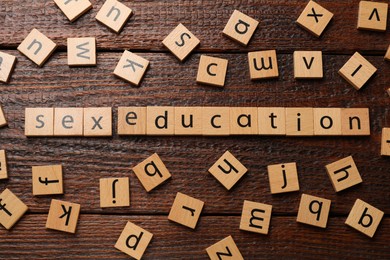 Photo of Phrase Sex Education made with wooden letters on table, flat lay