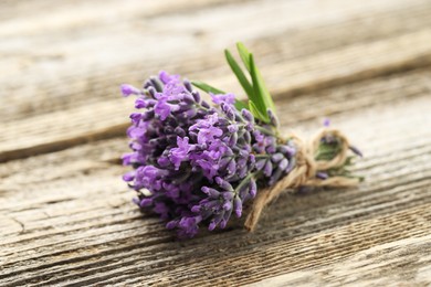 Photo of Bunch of beautiful lavender flowers on wooden table, closeup