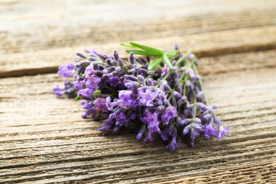 Photo of Bunch of beautiful lavender flowers on wooden table, closeup