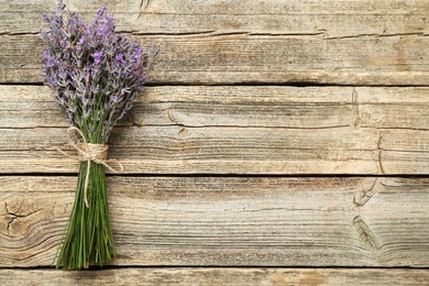 Photo of Bunch of beautiful lavender flowers on wooden table, top view. Space for text