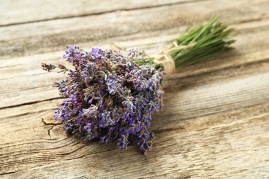 Photo of Bunch of beautiful lavender flowers on wooden table, closeup