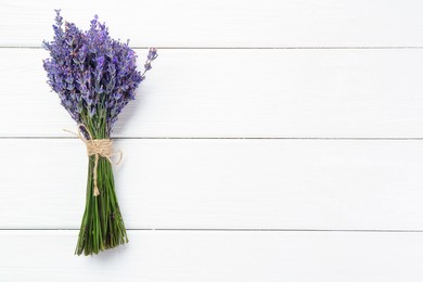 Photo of Bunch of beautiful lavender flowers on white wooden table, top view. Space for text