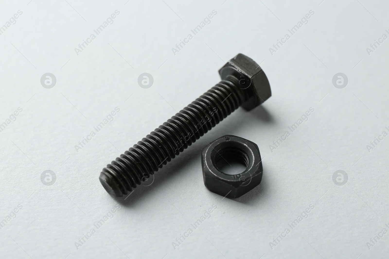 Metal bolt and nut on white background, closeup. Hardware tool Photo of Metal bolt and nut on white background, closeup. Hardware tool