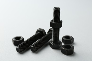 Photo of Metal bolts and nuts on white background, closeup. Hardware tool