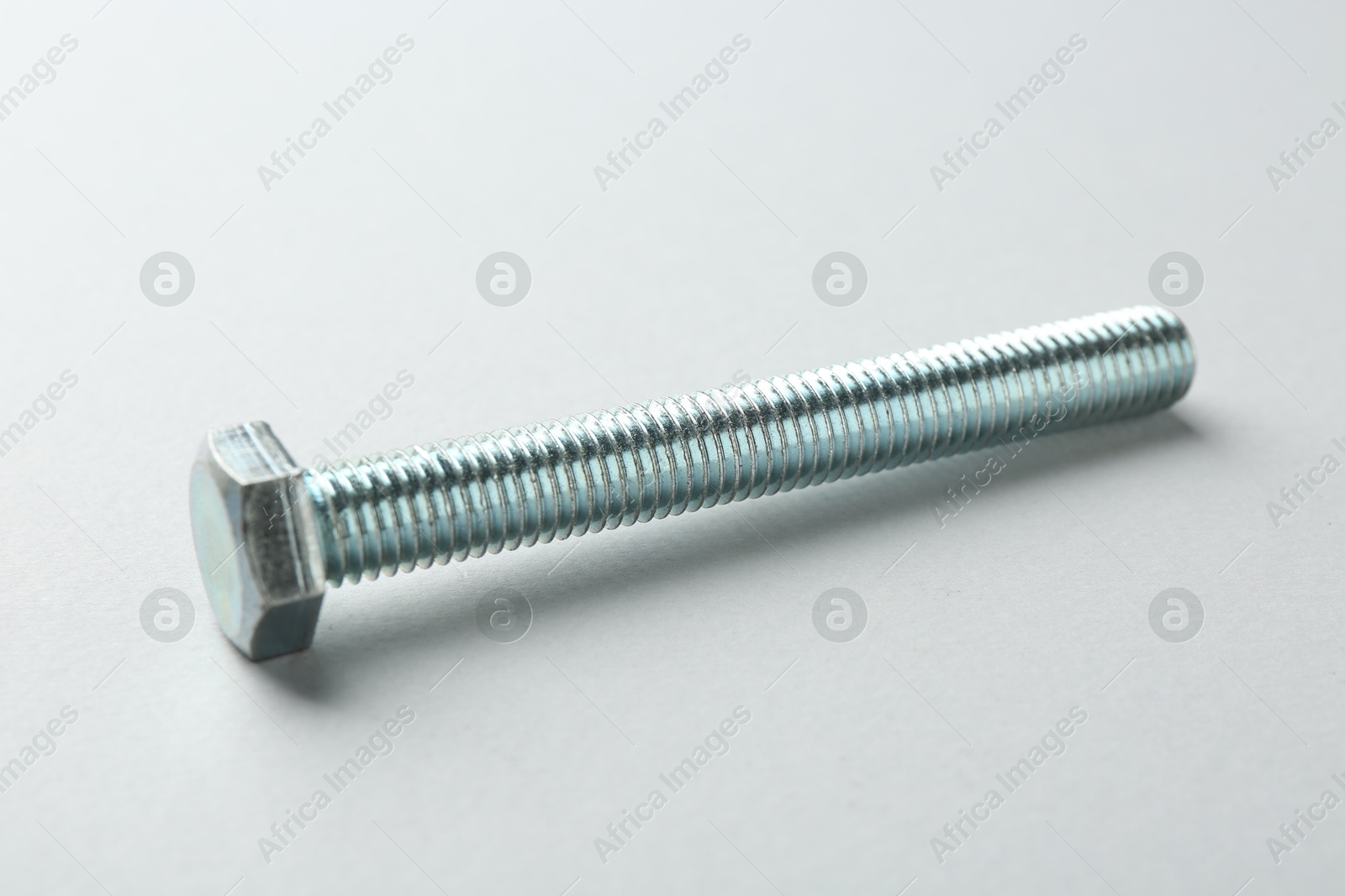 One metal bolt on white background, closeup. Hardware tool Photo of One metal bolt on white background, closeup. Hardware tool