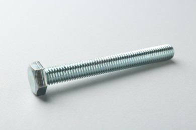 Photo of One metal bolt on white background, closeup. Hardware tool