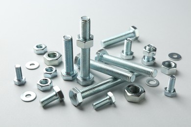 Photo of Metal bolts and nuts on white background, closeup. Hardware tool