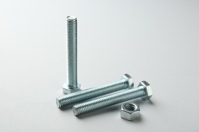 Photo of Metal bolts and nut on white background, closeup. Hardware tool