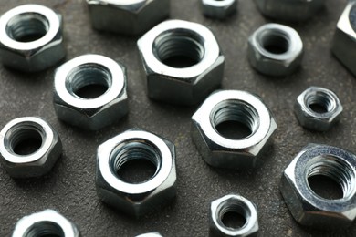 Photo of Metal hex nuts on grey table, closeup