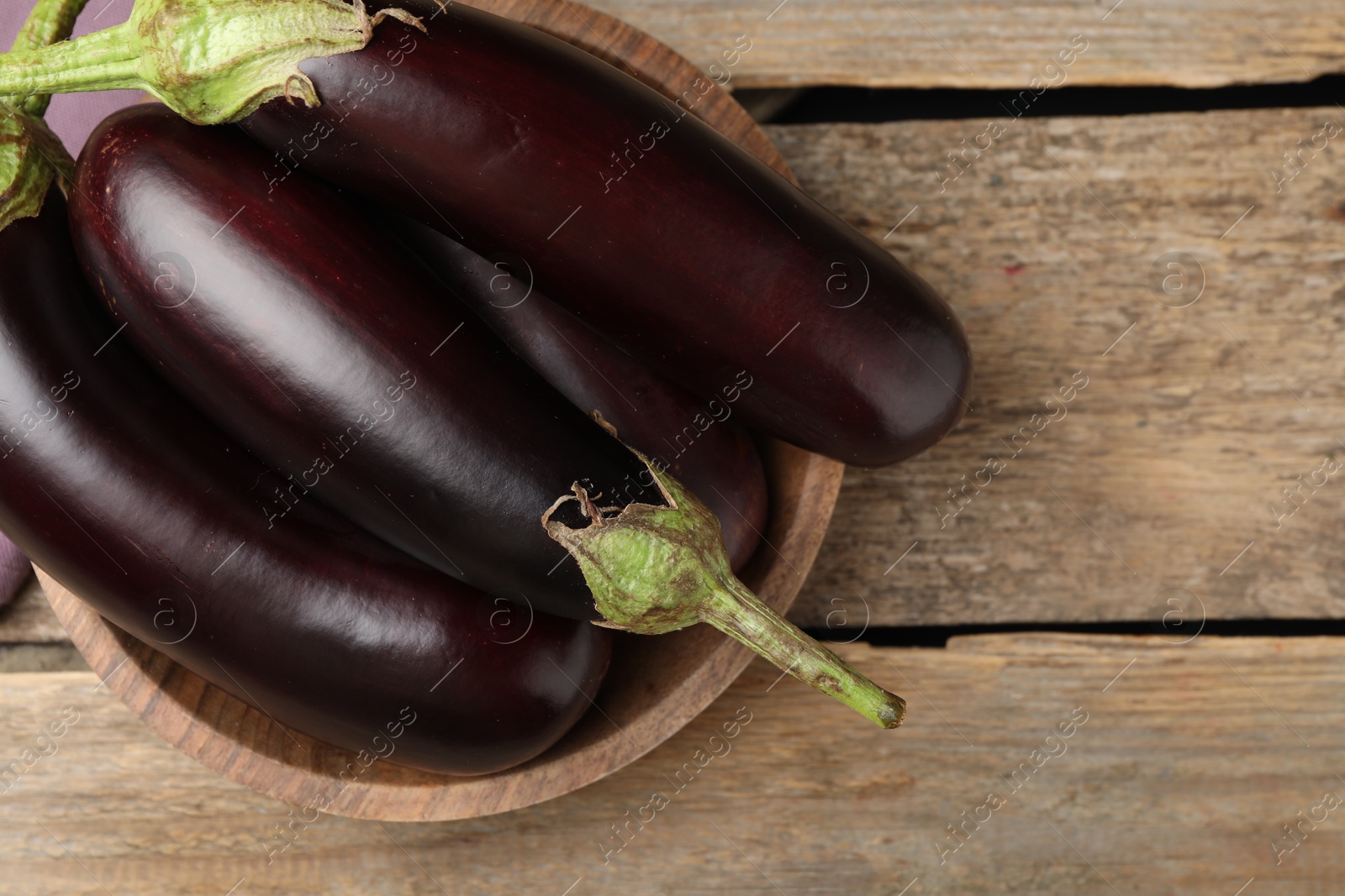 Photo of Many ripe eggplants on wooden table, top view