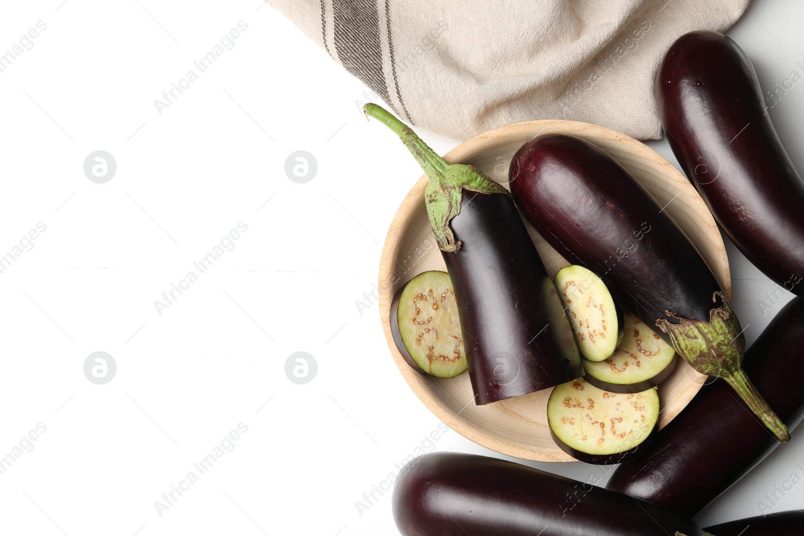 Photo of Whole and cut eggplants on white table, flat lay. Space for text