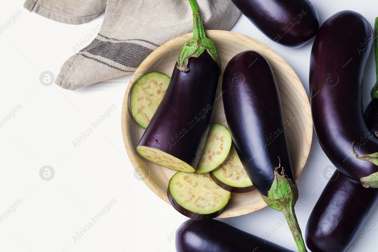 Photo of Whole and cut eggplants on white table, flat lay. Space for text