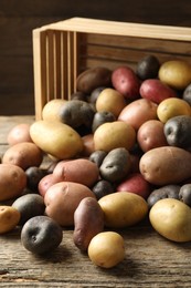 Photo of Different types of potatoes on wooden table, closeup