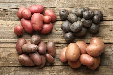 Photo of Different types of potatoes on wooden table, flat lay