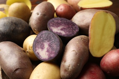 Photo of Different types of potatoes on table, closeup