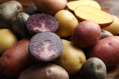 Photo of Different types of potatoes on table, closeup