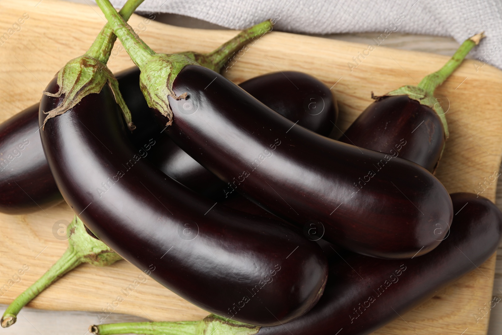 Photo of Many ripe eggplants on light wooden table, top view