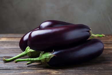 Photo of Many ripe eggplants on wooden table, closeup