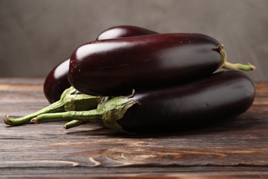 Photo of Many ripe eggplants on wooden table, closeup